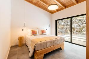 a bedroom with a bed and a large window at Casa Al Mare in Canto da Areia +60 photos