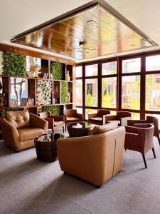 a living room with couches and chairs and windows at The Holiday Resort Pattaya in Pattaya