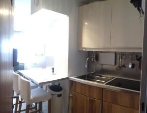 a kitchen with white cabinets and a sink and a counter at Les Lauzes - Freeloc Immobilier in Les Menuires +30 photos
