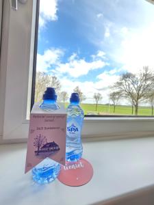 two bottles of water sitting next to a window at B&B Bokkeleane in Kolderwolde +6 photos