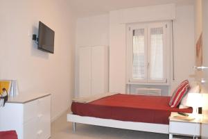 1 dormitorio con cama roja y ventana en Appartamenti nonna Dina, en Florencia