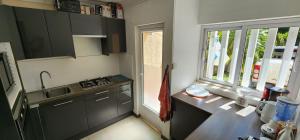 a kitchen with gray cabinets and a sink and a window at Charming house in Mauritius in Bain Boeuf