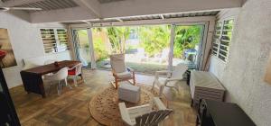 a living room with a table and chairs and a desk at Charming house in Mauritius in Bain Boeuf