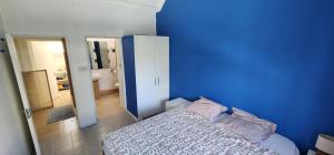 a blue room with a bed and a bathroom at Charming house in Mauritius in Bain Boeuf