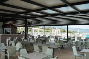 a dining area with tables and chairs and windows at Archontiko Kiverniti in Pano Lefkara