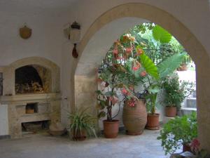 an archway with potted plants and a fireplace at Pension Castello in Rethymno