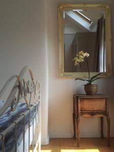 a mirror and a table with a potted plant on it at Hillside Cottage in Wirksworth