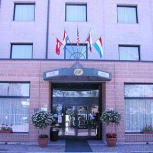 un bâtiment avec drapeaux devant lui dans l'établissement Hotel Executive Meeting & Events, à Udine