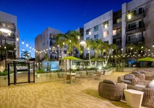 a courtyard in a building with chairs and umbrellas at Artistic Getaway 10 Min to Disneyland With Pool&GYM in Tustin