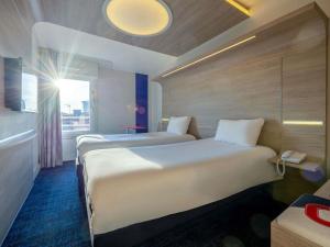 a hotel room with two beds and a window at ibis Styles La Rochelle Centre Vieux Port in La Rochelle +105 photos