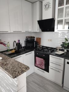 a kitchen with white cabinets and a black stove top oven at Deako in Kobuleti