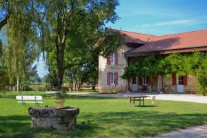 a building with a picnic table in the yard at La Ferme du Domaine de Bassol – Piscine & Billard in Mézériat