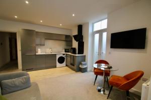 a kitchen and living room with a table and a television at Penthouse new 2 bed 2 apartment in Basingstoke