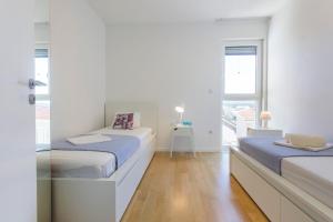 a white room with two beds and a window at Apartments Zorka in Primošten