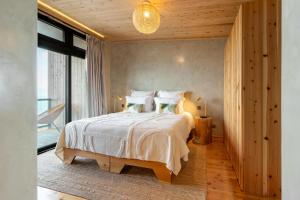 a bedroom with a large bed with white sheets and pillows at Casa da Faia in São Roque do Pico