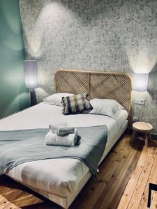 a bedroom with a bed with two towels on it at La Ferme du Domaine de Bassol – Piscine & Billard in Mézériat