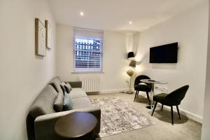 a living room with a couch and a table at Penthouse new 2 bed 2 apartment in Basingstoke