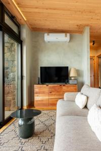 a living room with a couch and a flat screen tv at Casa da Faia in São Roque do Pico