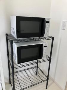 two microwaves sitting on a rack next to a microwave at Hotel Route35 Shiomi in Sasebo