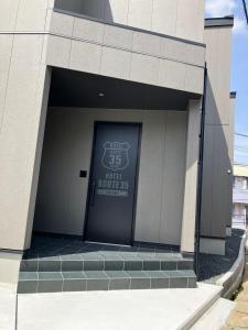 a building with a door with a sign on it at Hotel Route35 Shiomi in Sasebo