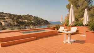 a patio with a pool and a table and umbrellas at Finca Victoria, a Member of Design Hotels in Begur