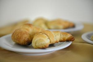 two croissants are sitting on plates on a table at Hotel Lilian in Puerto Iguazú