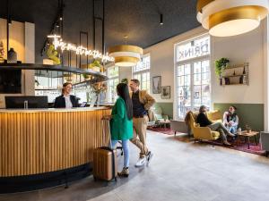 people standing at a bar in a restaurant at Hotel Novotel Brussels Off Grand Place in Brussels