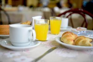 a table with a plate of bread and cups of orange juice at Hotel Lilian in Puerto Iguazú