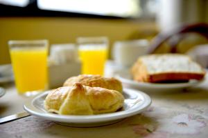 two plates of pastries on a table with two glasses of orange juice at Hotel Lilian in Puerto Iguazú