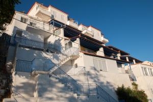 a white building with stairs on the side of it at Paris-Irini Studios And Apartments in Plomari