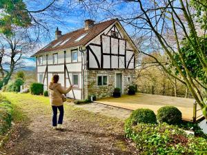 a woman standing in front of a house at Vakantiebungalow Maison7 in Plombières