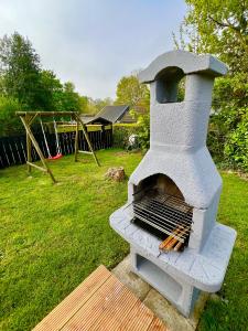 a stone oven in a yard with a playground at Vakantiebungalow Maison7 in Plombières