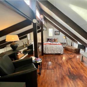 a attic bedroom with a bed and a couch at Vakantiebungalow Maison7 in Plombières