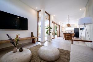 a living room with a tv on the wall at Villa Ume Seseh in Munggu