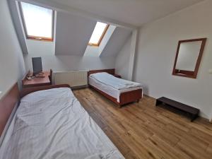 an attic bedroom with two beds and a mirror at Hostel RAV in Tomaszów Mazowiecki