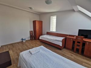a bedroom with two beds and a television in it at Hostel RAV in Tomaszów Mazowiecki