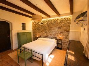 a bedroom with a bed and a brick wall at Tenuta di Valmarino - Adults only in Corciano
