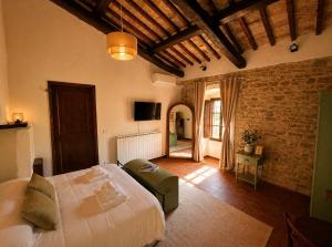 a bedroom with a large bed and a brick wall at Tenuta di Valmarino - Adults only in Corciano