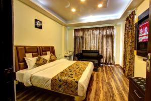 a hotel room with a bed and a television at The Moniker Resort in Manāli