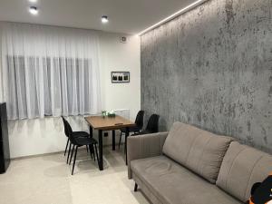 a living room with a couch and a table at Apartamenty Leszczynowa 7 blisko Zatora in Spytkowice