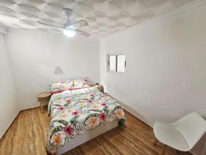 a white bedroom with a bed and a white chair at MarDeSantaPola in Santa Pola