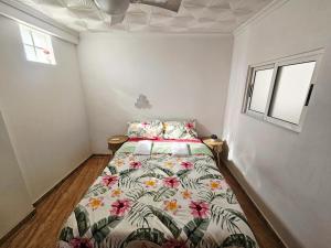 a bedroom with a bed with a floral comforter at MarDeSantaPola in Santa Pola