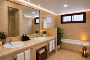 a bathroom with two sinks and a large mirror at Alta Luminara Boutique Residence Sea View Terraces Marbella Hills in Benahavís