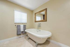 a bathroom with a white tub and a mirror at Home with pool by Dream Vacation in Fort Lauderdale