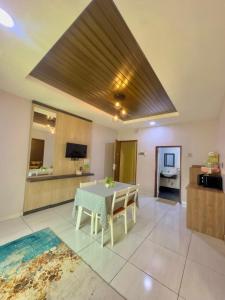 a living room with a table and a kitchen at Grand Village Inn in Pantai Cenang
