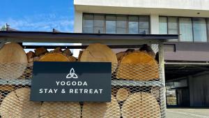 a sign in front of a building with hay and retreat at ヨゴダステイアンドリトリート Yogoda Stay & Retreat in Ina