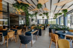 a restaurant with blue tables and chairs and plants at Nyota Hotel & Conference Center in Mamaia