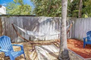 a yard with two chairs and a hammock next to a fence at Beach Apart by Dream Vacation unit 1 in West Palm Beach