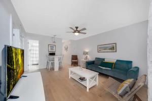a living room with a blue couch and a tv at Beach Apart by Dream Vacation unit 1 in West Palm Beach