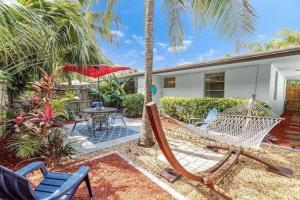 a porch with a hammock and a table and chairs at Beach Apart by Dream Vacation unit 1 in West Palm Beach